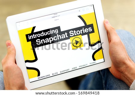 Venice,California-Jan 03:Man holding a tablet computer with opened homepage of Snapchat.com.Snapchat said it will release a new version of its app after hackers attack on January 3,2014 in Venice,USA.