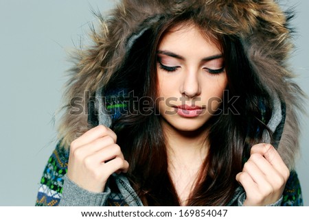 Closeup portrait of a young woman in warm winter outfit with closed eyes