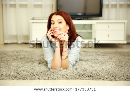 Cheerful woman resting on the floor at home