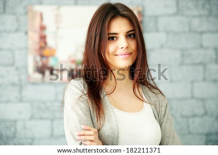 Portrait of a smiling woman near brick wall