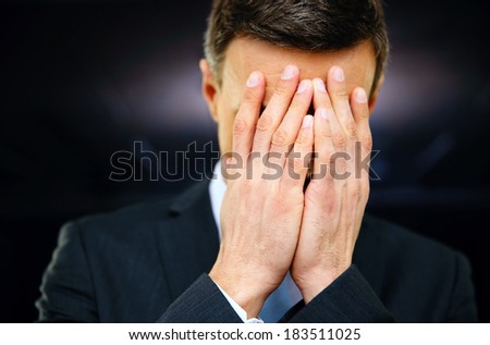 Frustrated businessman with hands on face