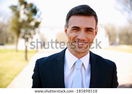 Portrait of a happy handsome businessman on the street