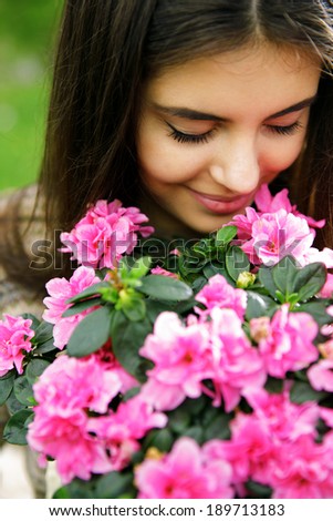 Young woman smelling pink flowers