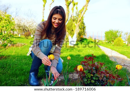 Gardening - happy woman cutting the flowers in the garden