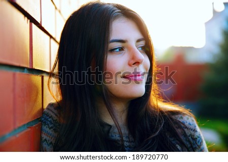 Portrait of a thoughtful woman near brick wall