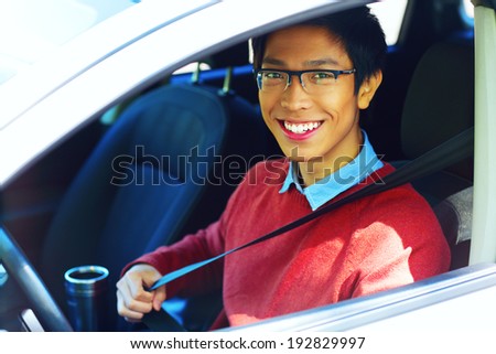 Handsome happy asian man in his new car