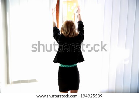 Back view portrait of a young woman looking at window