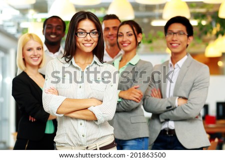 Smiling group of co-workers standing in office