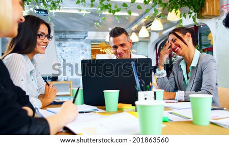 Happy businesspeople working together around the table in office