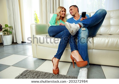 Happy and lovely young couple sitting on the sofa