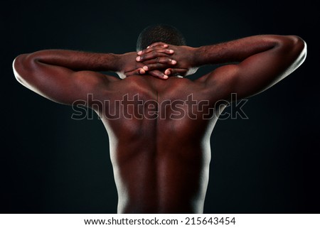 Back view portrait of a african man over black background