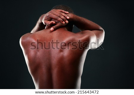 Back view portrait of a african man over black background