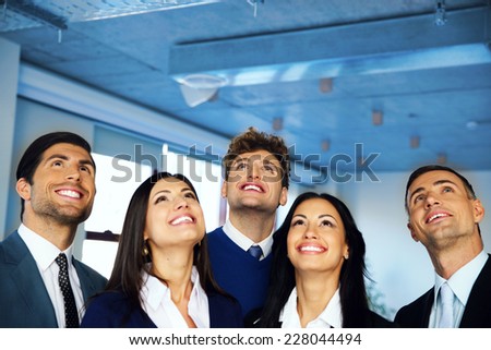 Happy positive business group looking up with dreaming expression