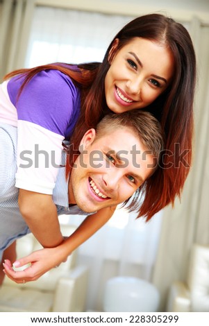 Funny happy couple hugging at home