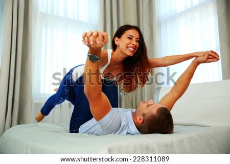 Happy couple playing on the bed. Flying concept.
