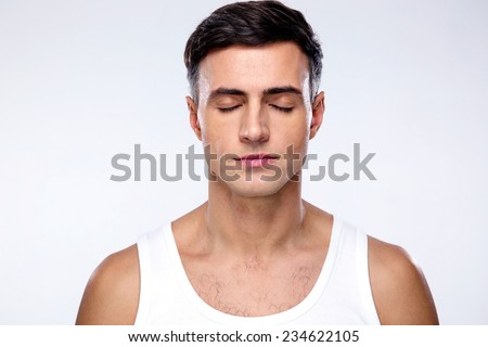 Handsome man with closed eyes over gray background