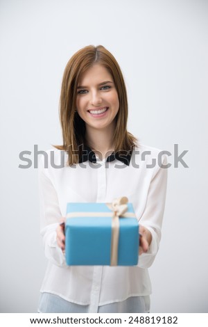 Portrait of a happy woman giving gift on camera