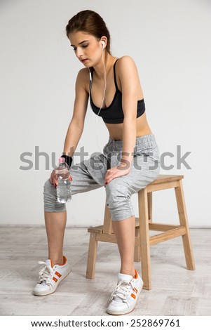 Portrait of a young sports woman sitting on the chair at gym