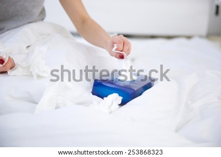 Closeup image of a female hand pulls out a napkin from the box