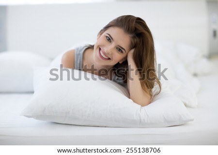 Happy smiling cute woman on the bed at home