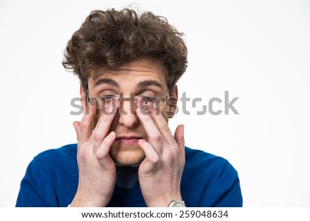 Young businessman rubbing his eyes over white background