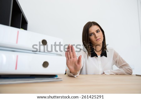 Young businesswoman sitting at the table and saying - No