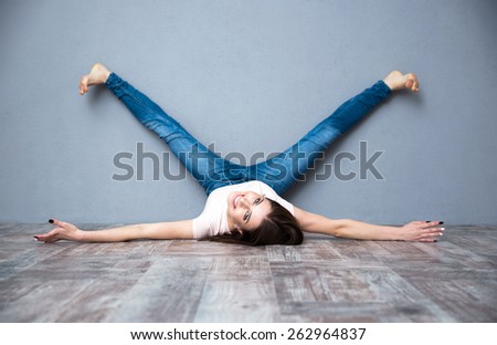 Funny beautiful woman lying on the floor with legs raised up