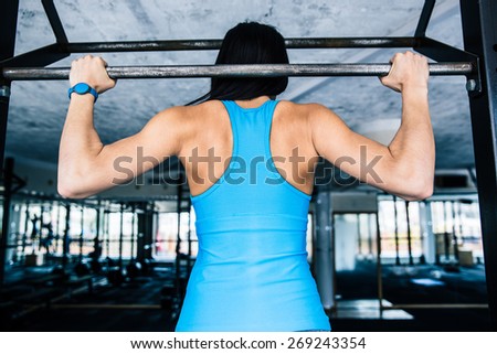 Back view portrait of a fit woman working out at gym
