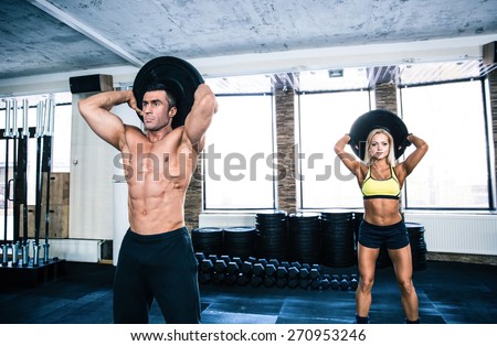 Muscular man and fit woman workout at crossfit gym