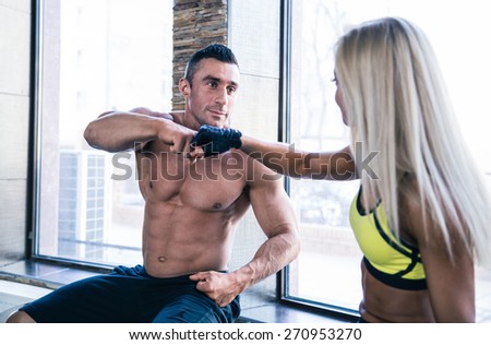 Portrait of a muscular man with woman resting in gym