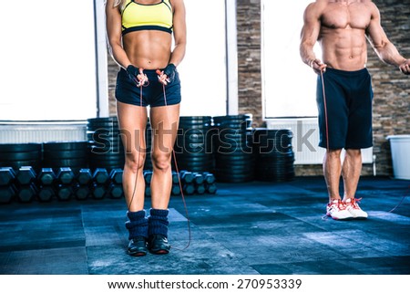 Man and woman workout with jumping rope at crossfit gym
