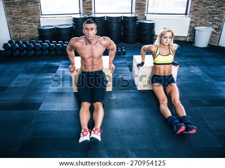 Man and woman workout with hands on fit box at gym