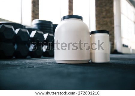 Closeup image of a plastic containers with sports nutrition in gym