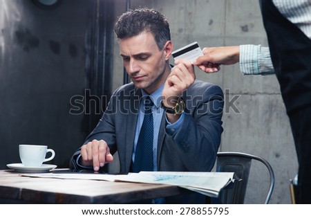 Confident man paying with credit card at the restaurant