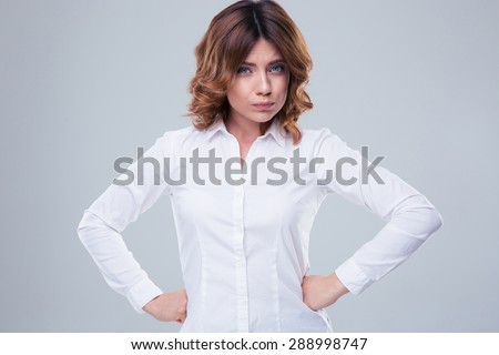 Portrait of a cute offended woman looking at camera over gray background