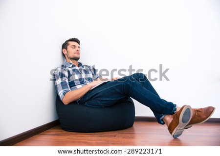 Casual man resting on the bag chair with headphones