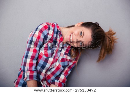 Funny cute woman with ponytail looking at camera over gray background