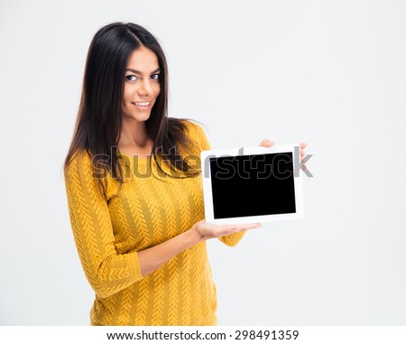 Portrait of a smiling beautiful woman showing blank tablet computer screen isolated on a white background. Looking at camera