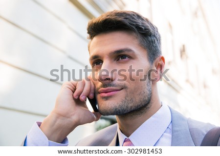 Portrait of a happy businessman talking on the phone in the city