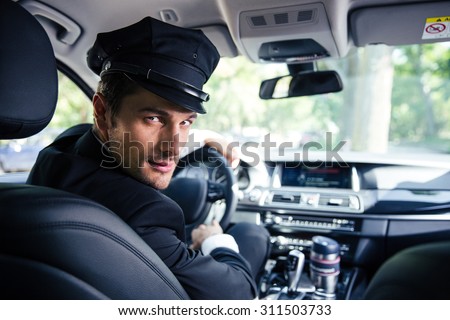 Portrait of a handsome male chauffeur sitting in a car