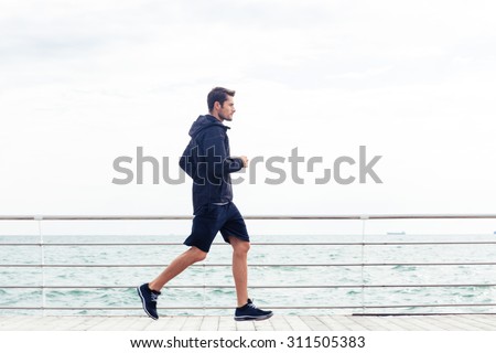Side view portrait of a sports man running outdoors