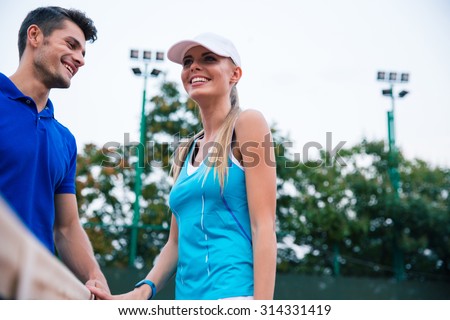 Portrait of a happy two tennis players talking outdoors