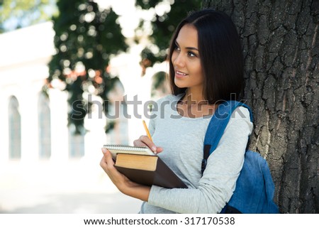 Portrait of a thoughtful female student standing and looking away outdoors