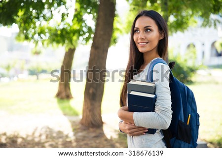 Portrait of a smiling female student walking outdoors