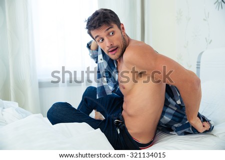 Portrait of young man dressing in hurry because he is late