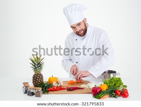 Portrait of a handsome male chef cook cutting vegetables isolated on a white background