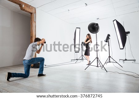 Photographer working with model in studio with equipments