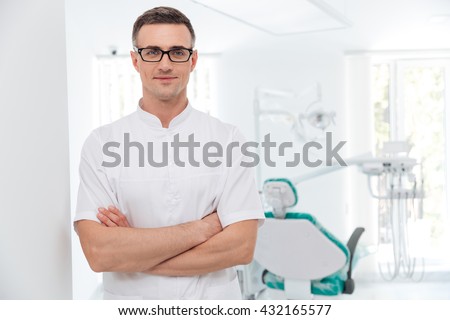 Female dentist standing with his hands crossed and looking at camera