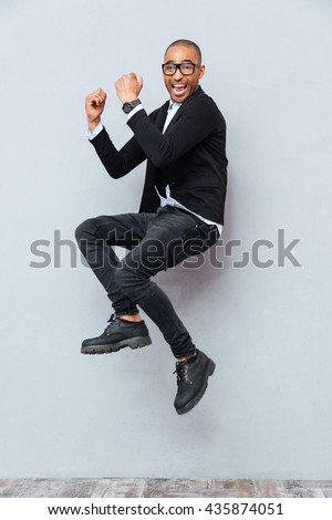 Happy excited african american young man jumping and celebrating success