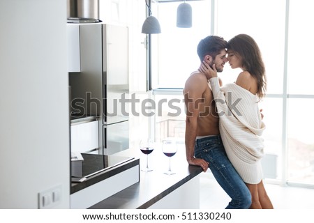 Sexy sensual young couple standing and hugging on the kitchen